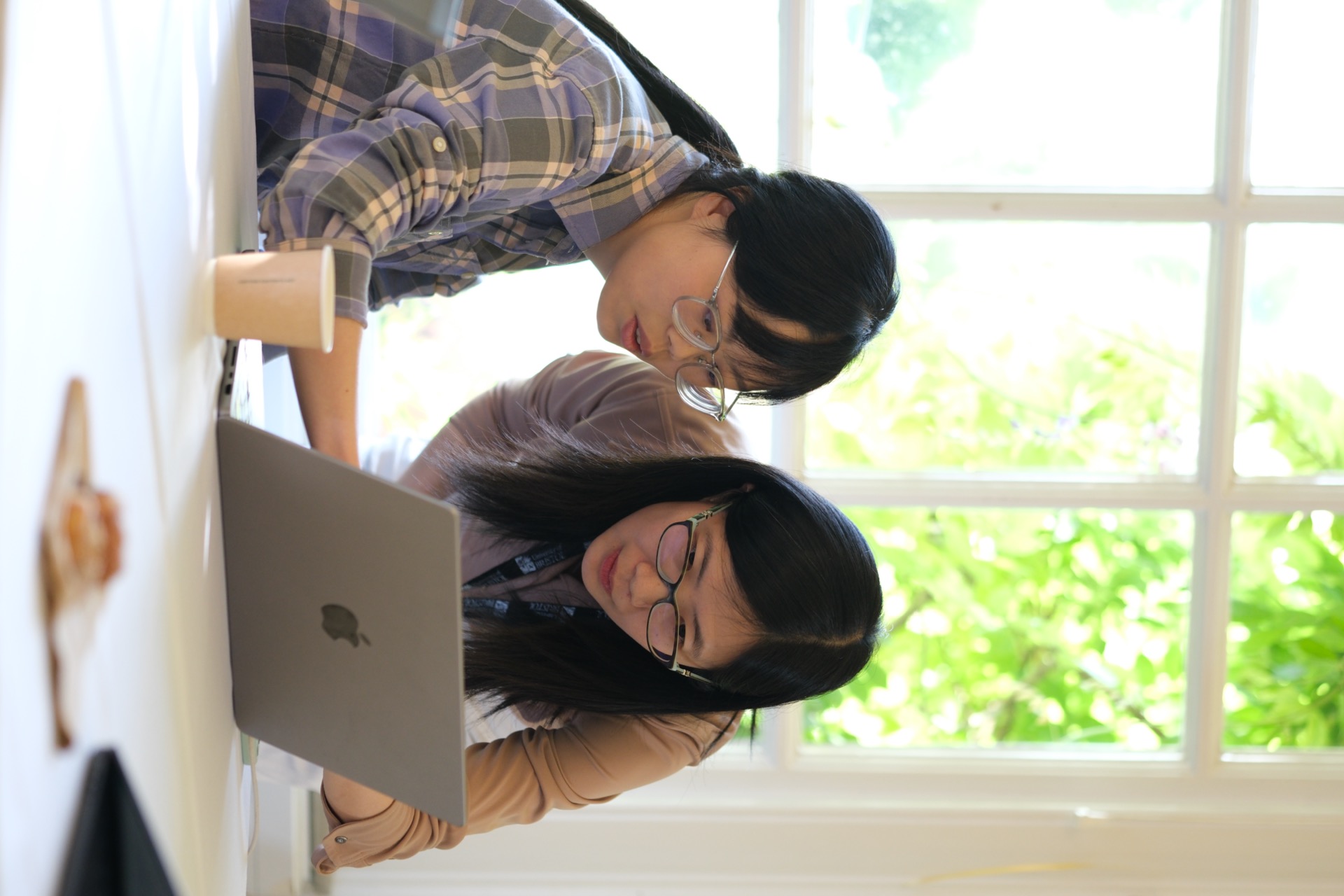 Dr Jin Zheng and Dr Wei Wei reviewing work together on a laptop