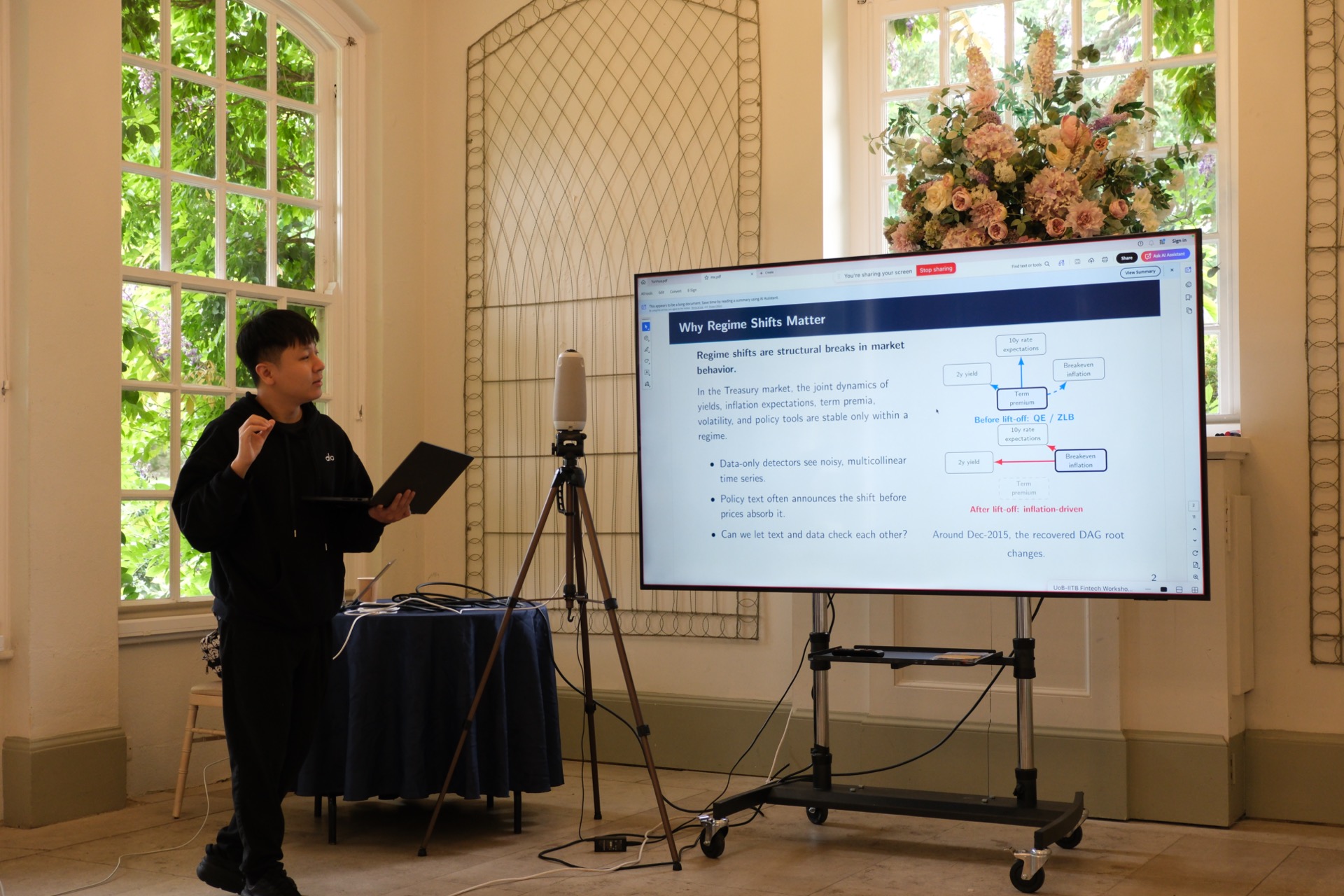 Presenter speaking beside a complete presentation slide